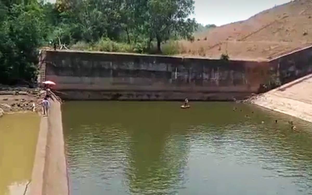 An official empties a reservoir to get his mobile phone back in India