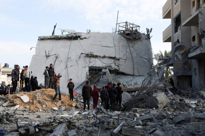 Palestinos reunidos junto a una casa bombardeada. Foto: Reuters