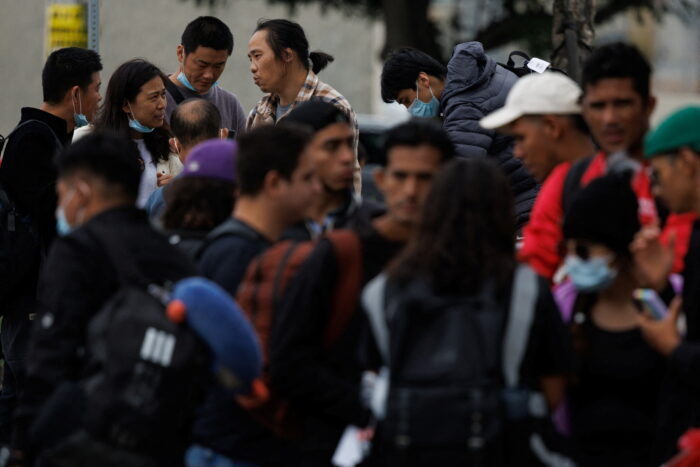 Migrants detained at the border and processed by U.S. Customs and Border Patrol wait at a transit center after being removed from a crowded bus in San Diego, California.
