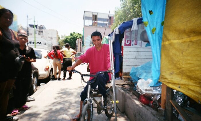 Alex, migrante de Venezuela, recorre el campamento en su bicicleta. Foto: Sergio Pérez Gavilán/MSF