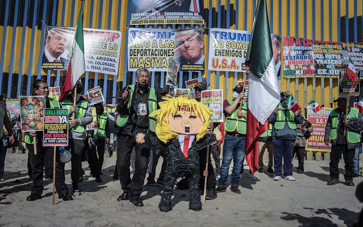 Migrantes protestan y dan nalgadas a piñata de Trump frente al muro fronterizo