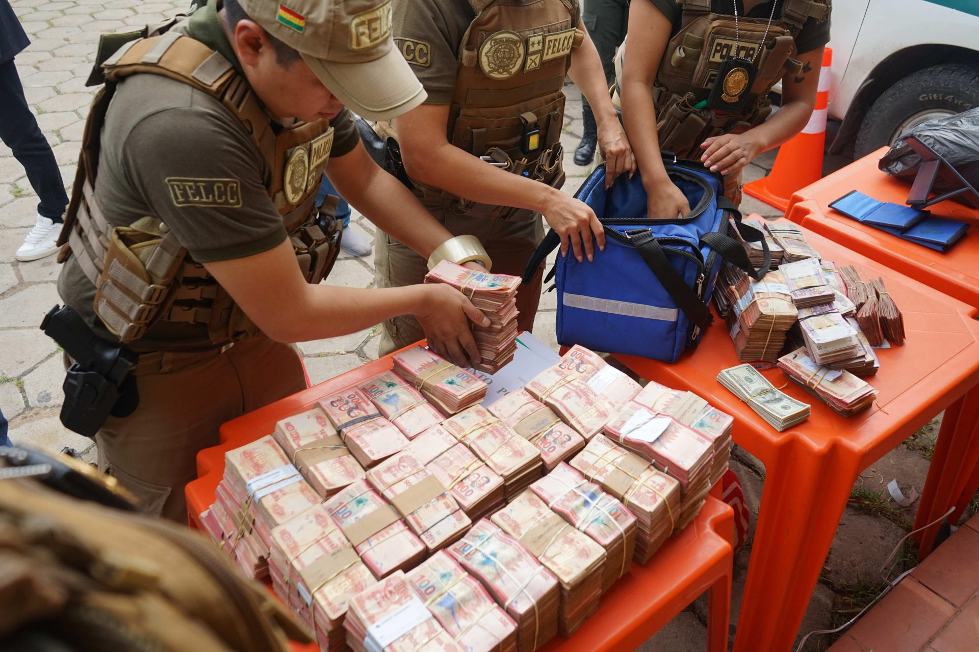 AME1982. SANTA CRUZ (BOLIVIA), 01/10/2026.- Integrantes de la Fuerza Especial de Lucha Contra el Crimen (FELCC) de Bolivia cuentan billetes que fueron encontrados en una ambulancia que salió del condominio donde vivía el fiscal general, Roger Mariaca, detenido y acusado de liderar una organización vinculada con el narcotráfico, este jueves en Santa Cruz (Bolivia). EFE/ Juan Pablo Roca