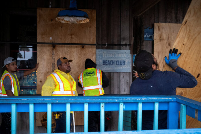Hombres colocan tablas en un restaurante mientras el huracán Isaías se mueve a través del Golfo de México y se prevé que se fortalezca antes de llegar a la costa del Golfo de Estados Unidos, en Pensacola Beach, Florida, EE. UU.